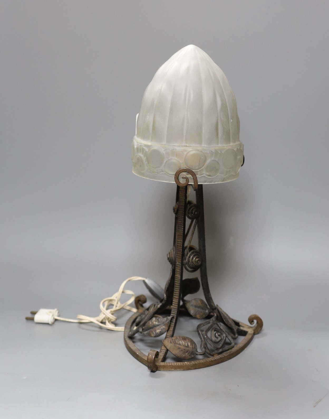 A French 1920's Edgar Brandt style wrought iron table lamp, with frosted glass shade, 38.5 cms high